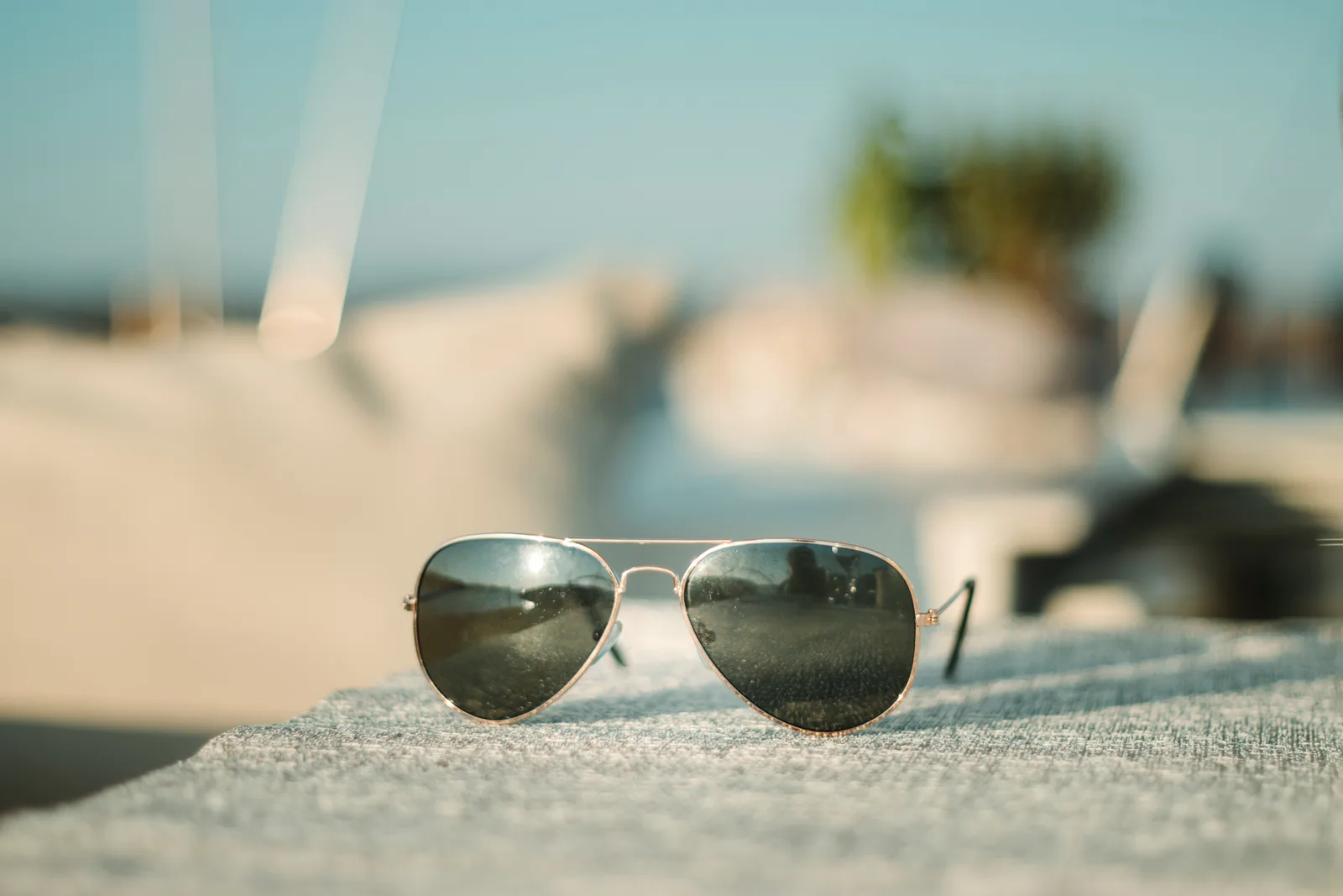 Aviator sunglasses resting on a sunlit rooftop, seen with the naked eye